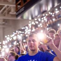 students holding cell phones with the light on during 2023 Fall Convocation